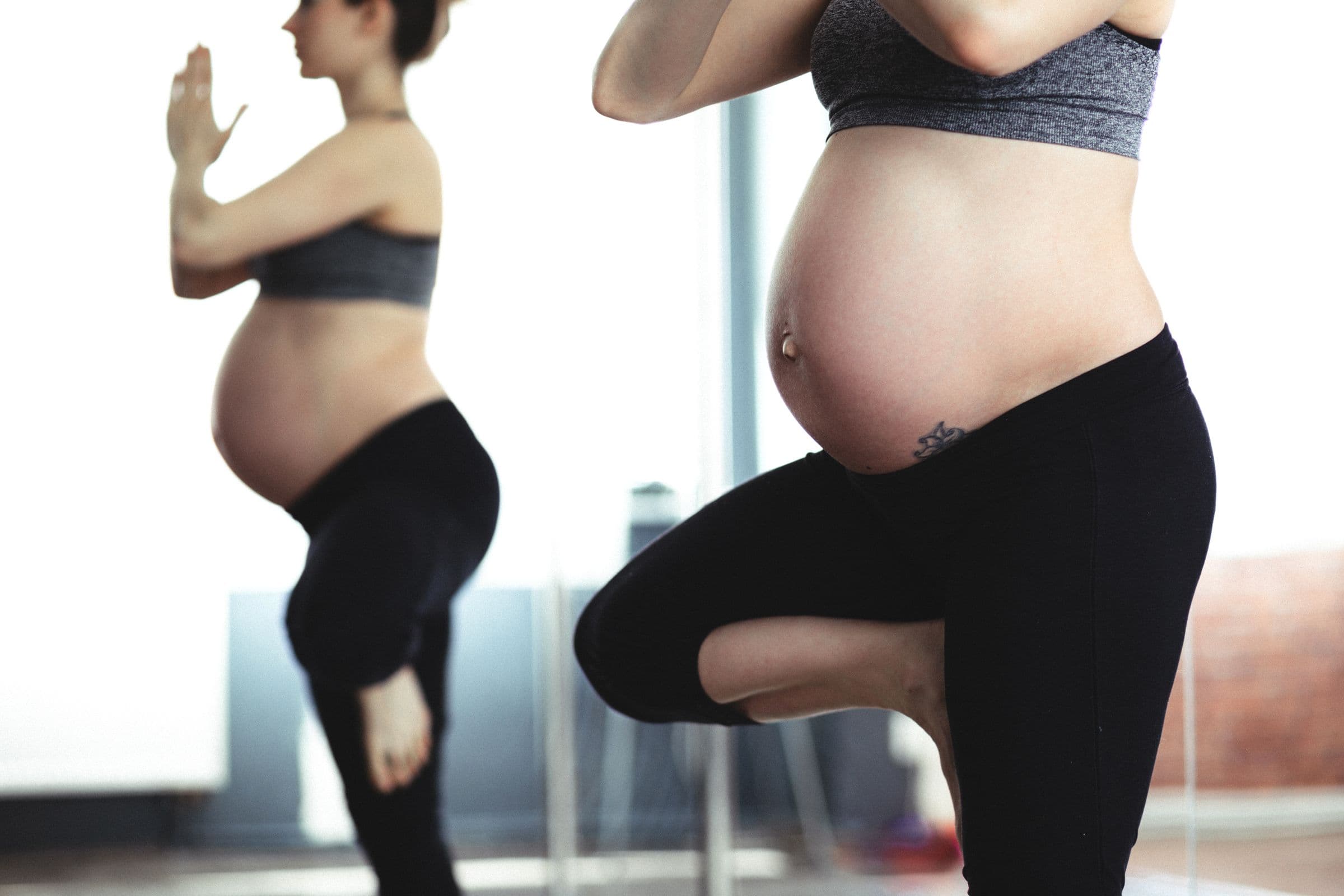 Schwangere Frau in der Baumhaltung, Nahaufnahme des Babybauchs